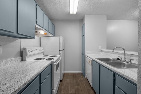 A kitchen with a white stove and blue cabinets.