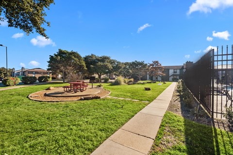 A park with a playground and a fence.