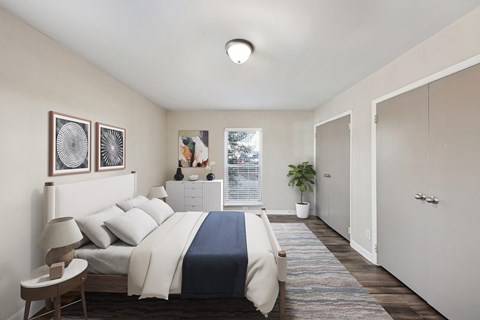 A bedroom with a bed, nightstand, and two framed pictures on the wall.