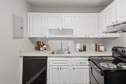 A white kitchen with black appliances and a black dishwasher.