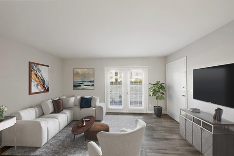 A living room with a white couch, a brown coffee table, and a painting on the wall.