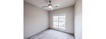 A room with a ceiling fan and a window.
