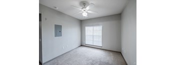 A room with a ceiling fan and a window with blinds.