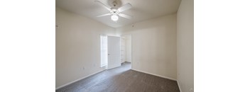 A room with a carpet floor and a ceiling fan.