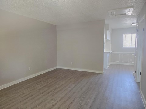 A room with wooden flooring and white walls.