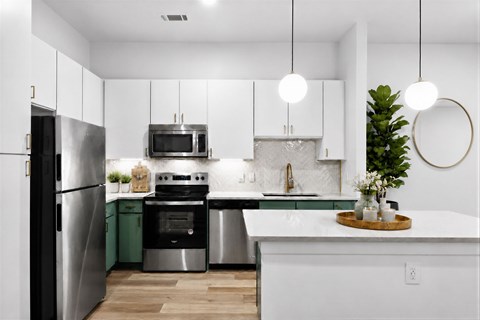A modern kitchen with a stainless steel refrigerator and a white countertop.