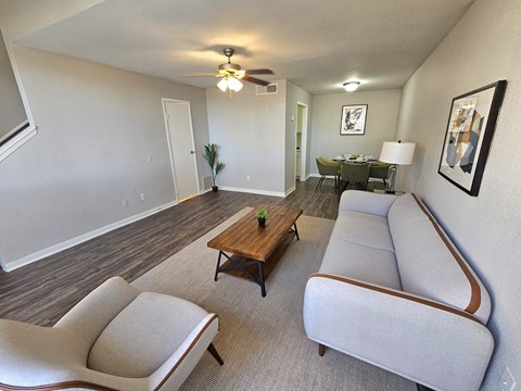 A living room with a grey couch and a wooden coffee table.