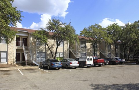 A parking lot with cars and a building in the background.