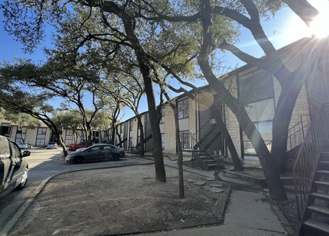 A tree-lined street with a car parked on the side.