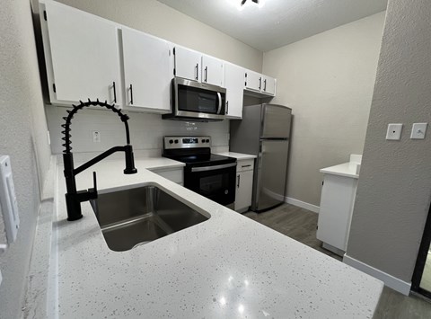 A kitchen with a sink and a microwave.