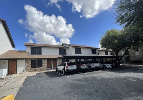 A parking lot with cars and a building in the background.
