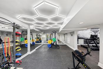 A gym with a variety of equipment including a rowing machine, a treadmill, and a stationary bike.