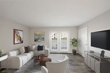 A living room with a white couch, a brown coffee table, and a painting on the wall.