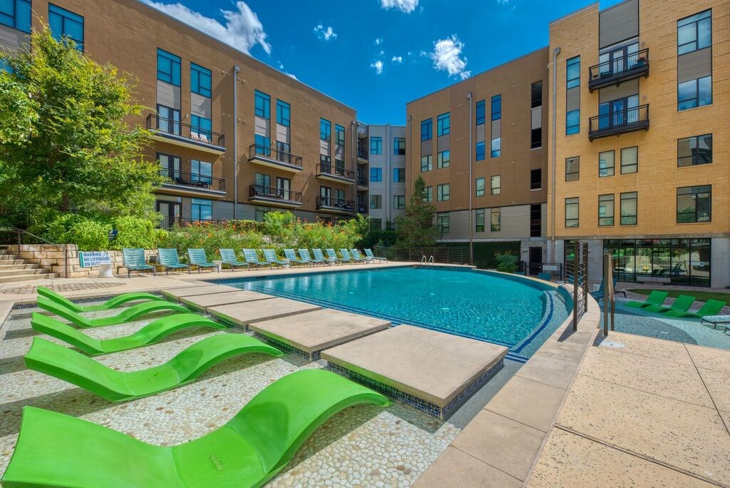 A swimming pool surrounded by apartment buildings.
