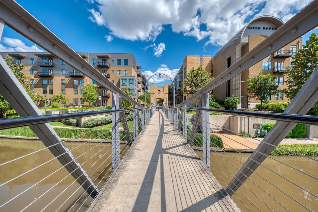 A bridge with a metal railing connects two buildings.