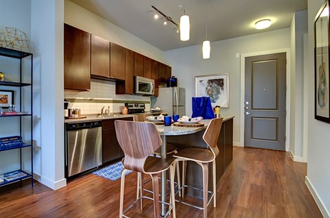 A kitchen with a table and chairs in the middle.