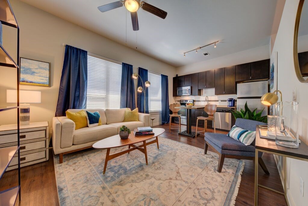 A living room with a white couch and a rug.