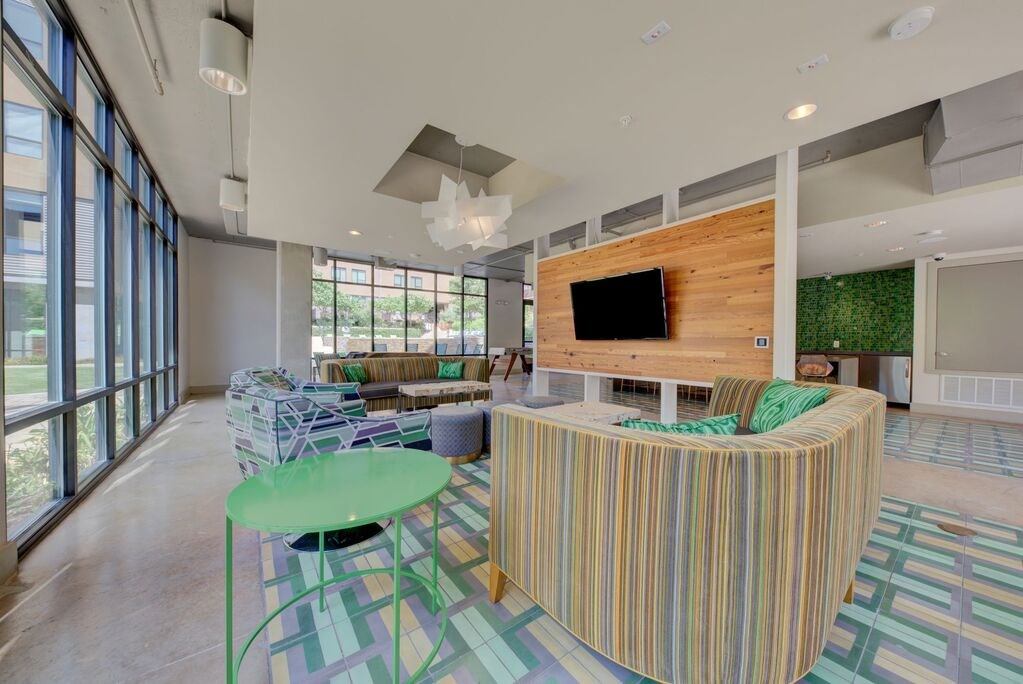 A living room with a green table and striped sofa.