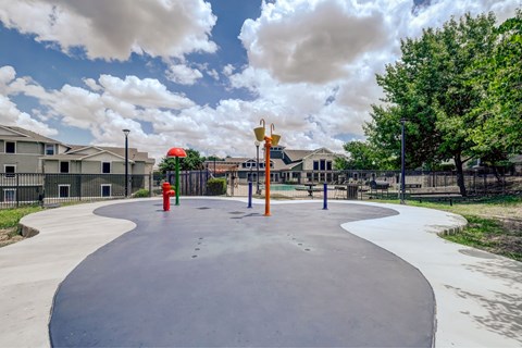 A playground with a slide and a red fire hydrant.