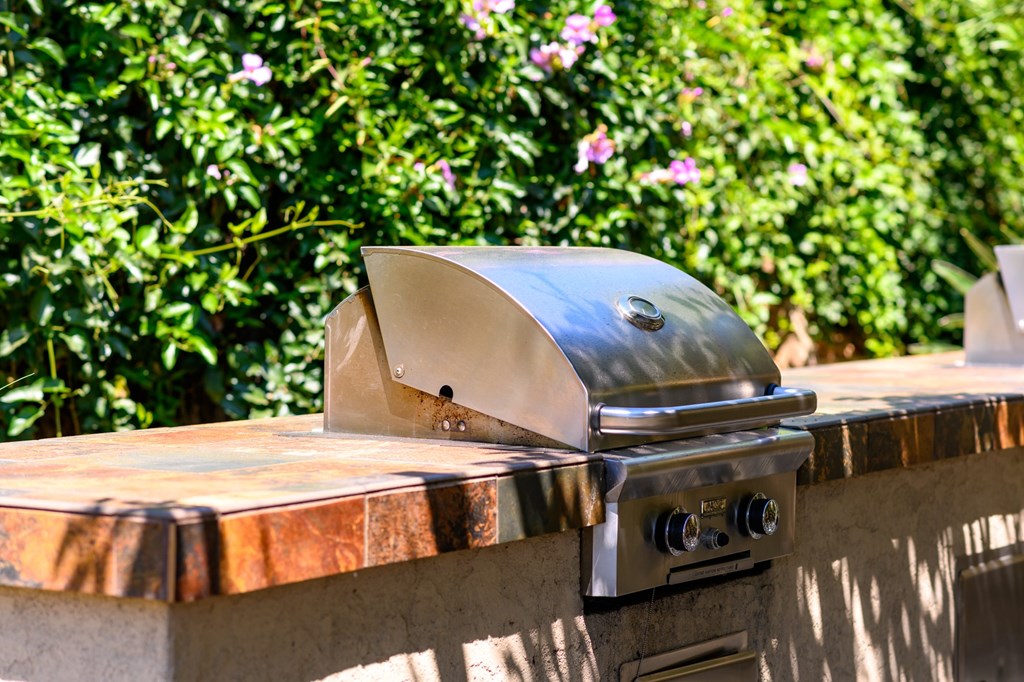A stainless steel grill with a lid on it.