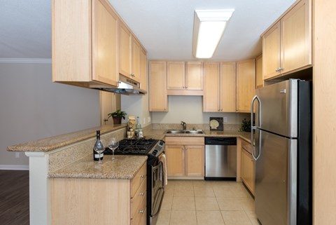 A kitchen with wooden cabinets and a granite counter top.