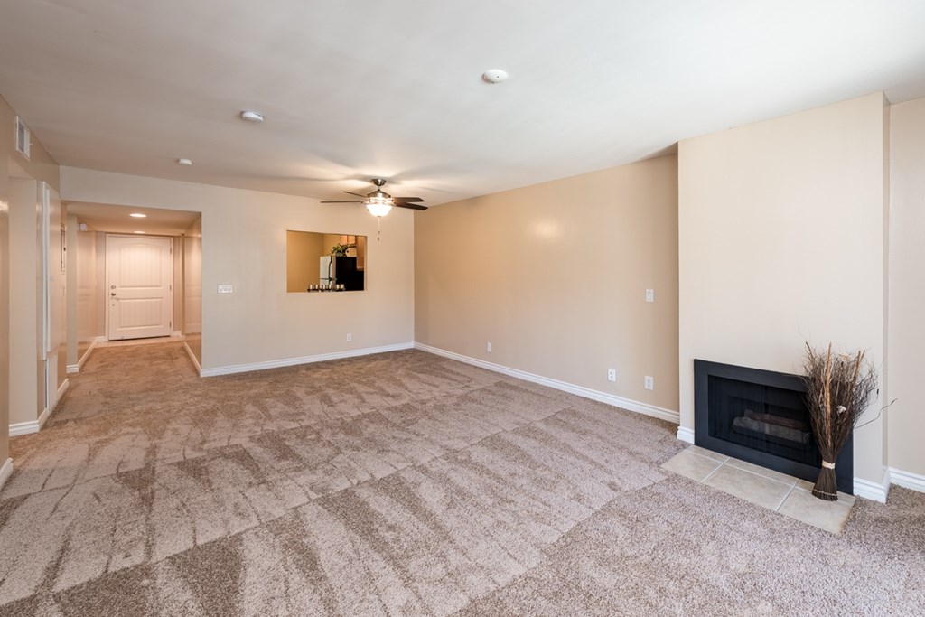 A living room with a fireplace and a ceiling fan.