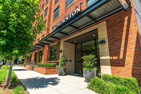 The entrance to a brick building with the word "Thornton" on it.