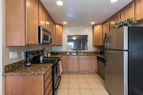 A kitchen with wooden cabinets and black appliances.