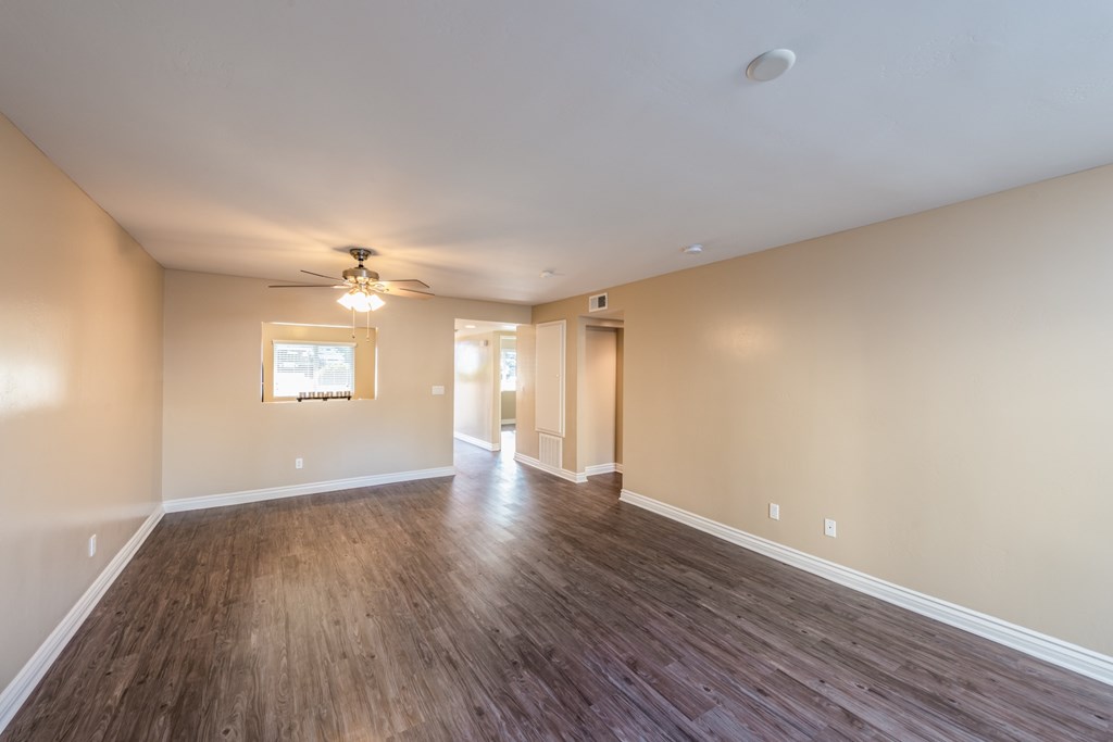 A room with wooden floors and a ceiling fan.