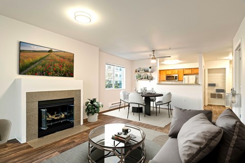 A living room with a fireplace and a painting on the wall.