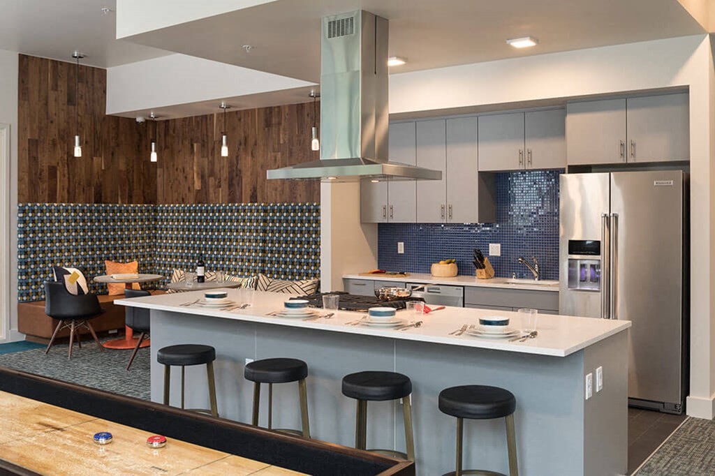 A kitchen with a bar area and a dining table. at Ravello Apartments, Redmond, Washington