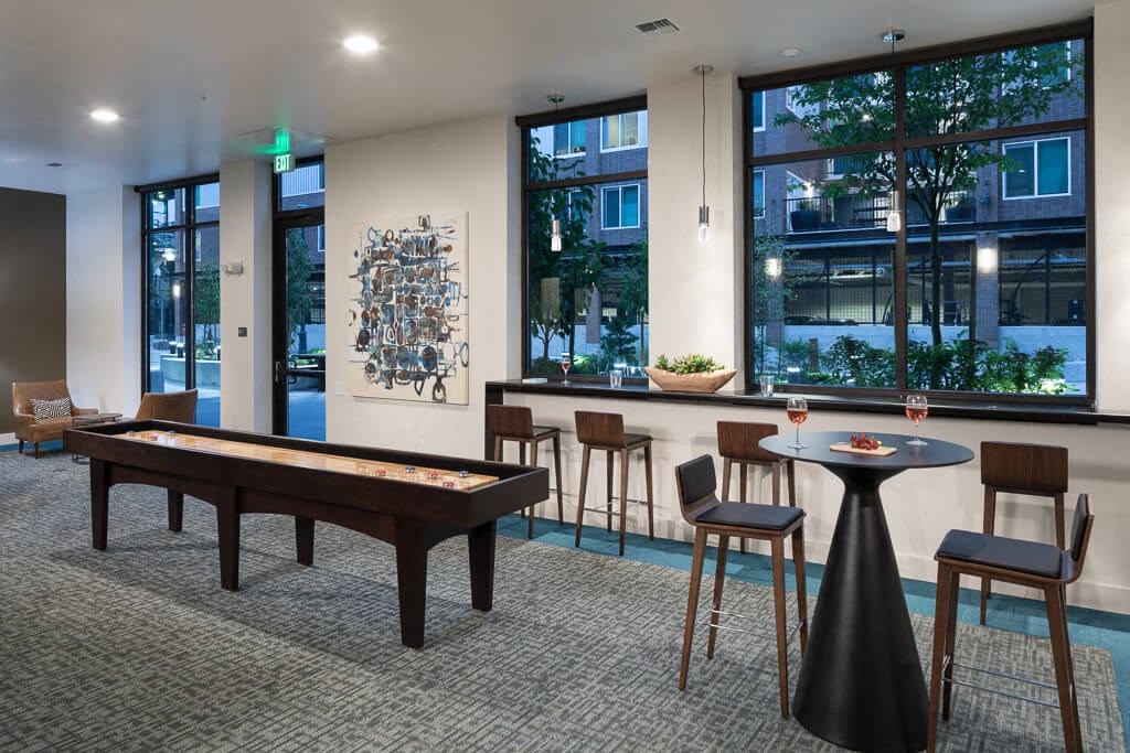 A room with a pool table, bar stools, and a table with chairs. at Ravello Apartments, Redmond, WA