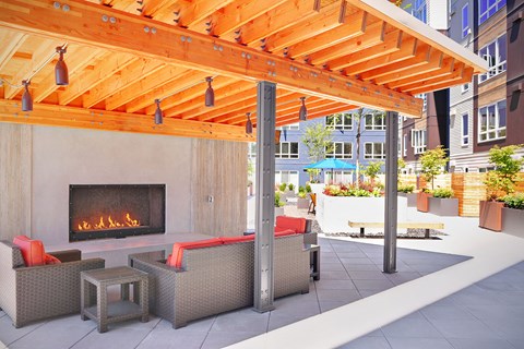 A patio with a fireplace and seating area. at Kirkland Crossing Apartments, Washington