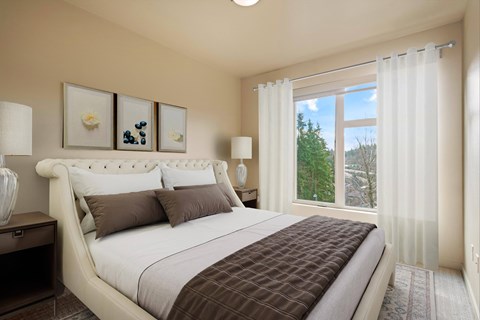 A bedroom with a large bed and two framed pictures on the wall.