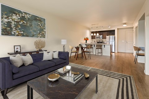 A living room with a dark blue sofa and a coffee table in front of it.