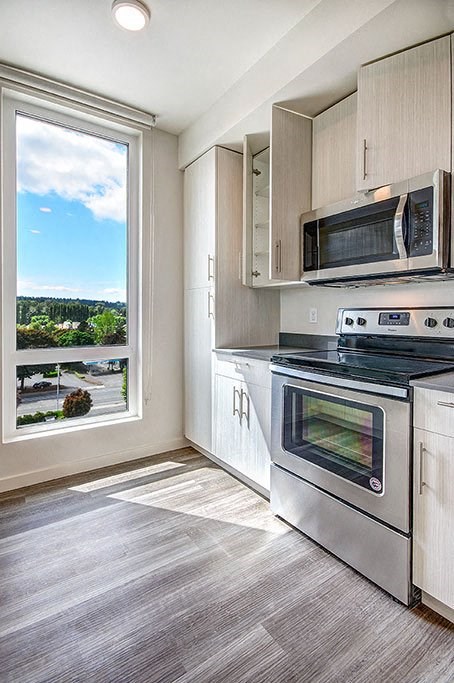 A modern kitchen with a stainless steel oven and microwave.