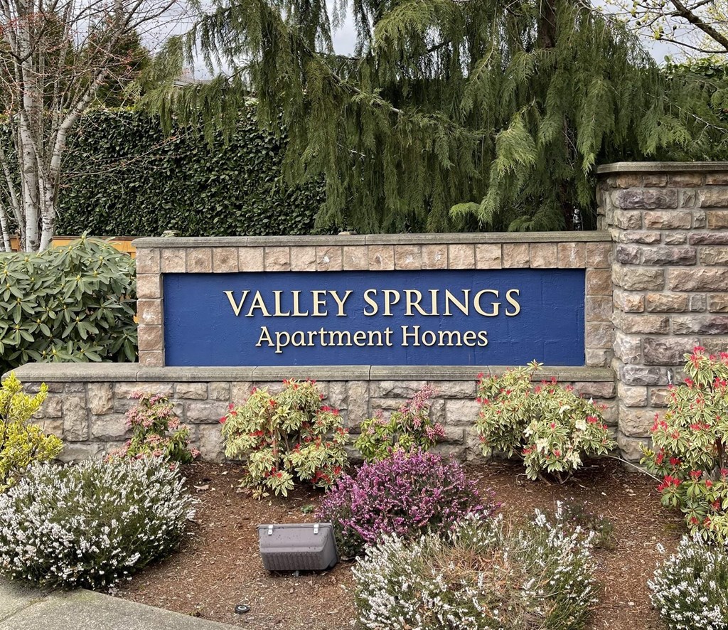 A sign that says Valley Springs Apartment Homes in front of a garden. at Valley Springs Apartments, Renton, WA