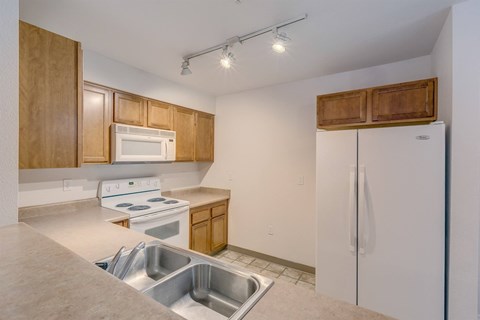 A kitchen with white appliances and wooden cabinets.