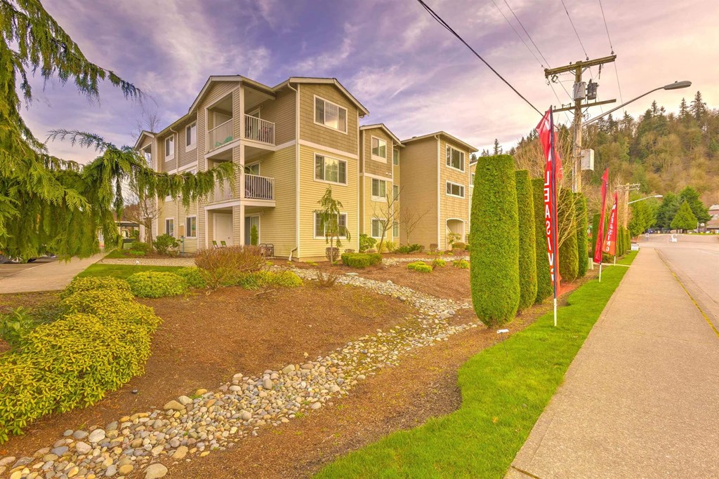 A residential building with a well-maintained garden in front. at Valley Springs Apartments, Renton 98058