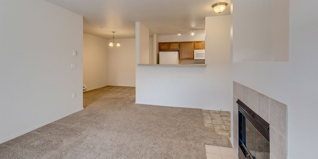 A room with a fireplace and a carpeted floor at Valley Springs Apartments, Washington
