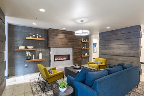 A modern living room with a fireplace and a blue couch. at Kirkland Crossing Apartments, Kirkland, WA