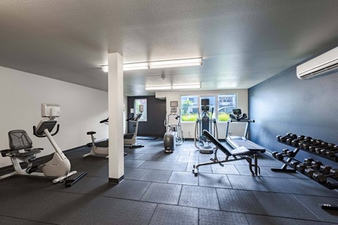 A gym with a variety of equipment including treadmills, weights, and exercise machines. at Kirkland Crossing Apartments, Kirkland, WA