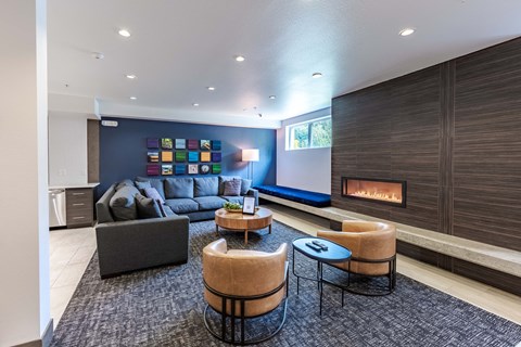 A modern living room with a fireplace and a grey sofa. at Kirkland Crossing Apartments, Kirkland, WA, 98033