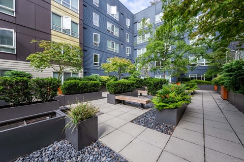 A courtyard with a bench and potted plants at Kirkland Crossing Apartments, Kirkland, WA, 98033