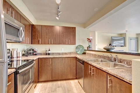 A kitchen with wooden cabinets and a granite countertop.
