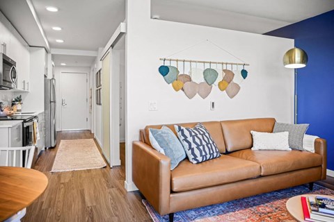 A living room with a brown couch and a blue wall.