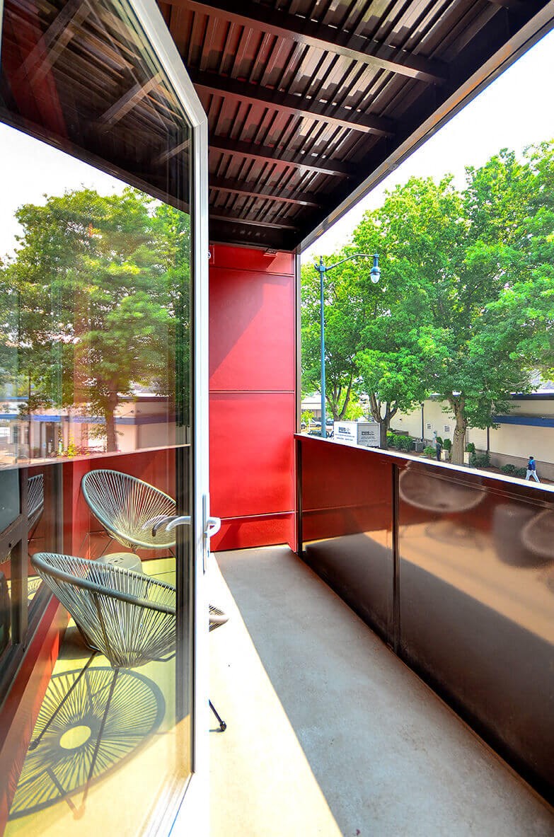 A red wall with a chair in front of it. at Ravello Apartments, Redmond, WA