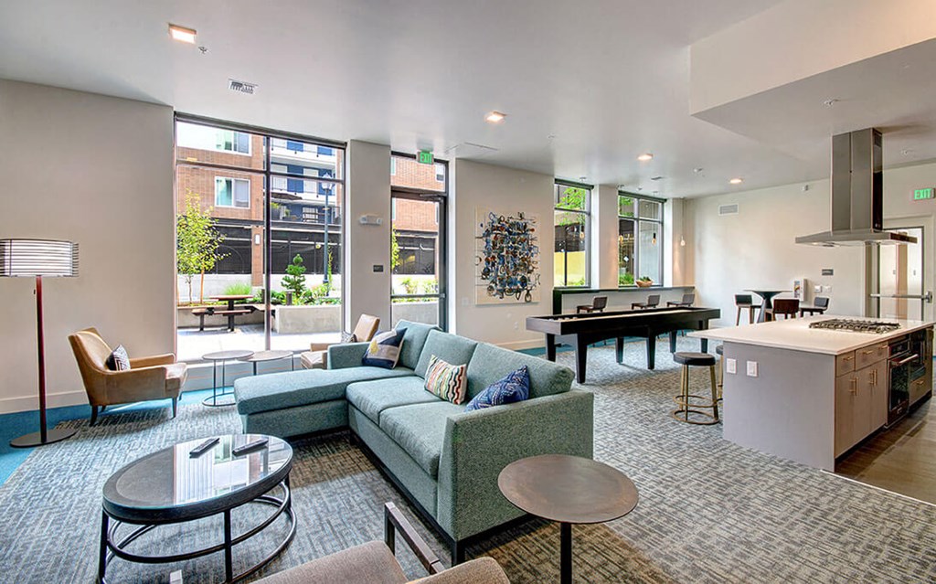 A modern living room with a kitchen area in the background. at Ravello Apartments, Redmond, Washington