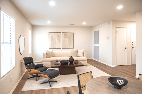 A modern living room with a black chair and a white couch.