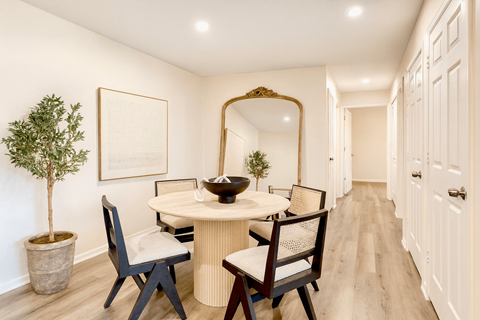 A dining room with a round table and chairs.